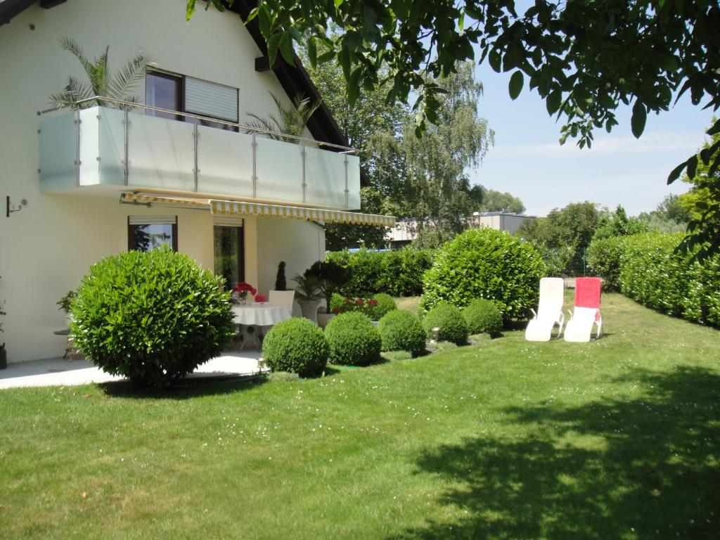 un patio con arbustos y un edificio con balcón en Apartment Rose, en Ahausen