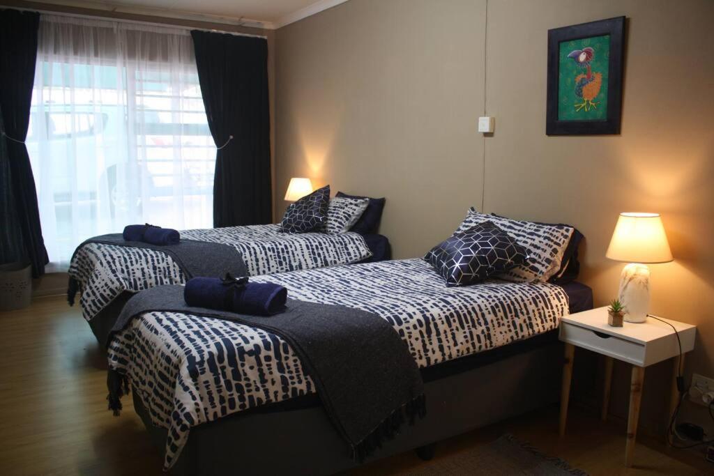 a bedroom with two beds and a window at Casa en Gregg -Exquisite 2-bedroom self catering unit - 1 car parking space in East London
