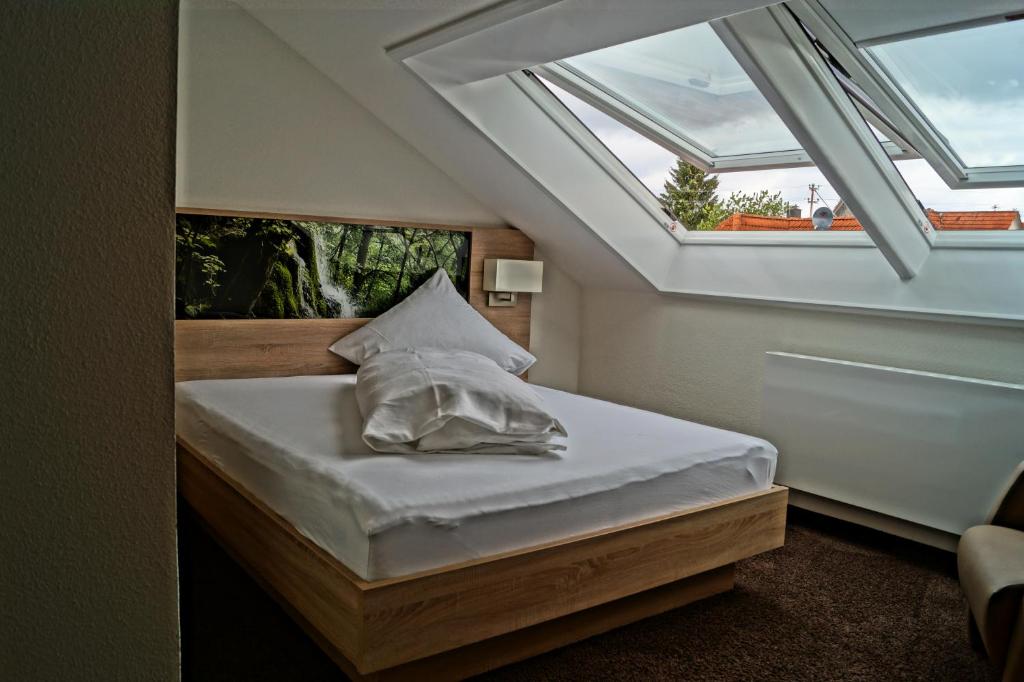 a small bedroom with a bed with a window at Gasthof Lamm in Grabenstetten
