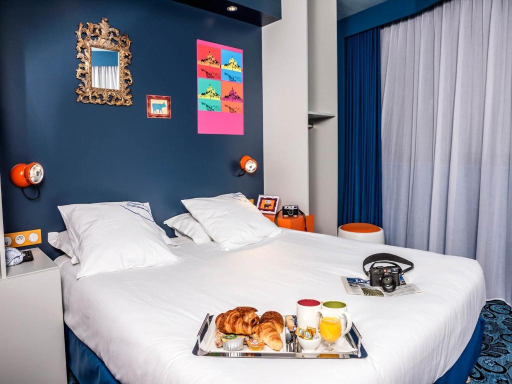 モンサンミッシェルにあるホテル ガブリエルのベッドに食料品のトレイを用意したホテルルーム