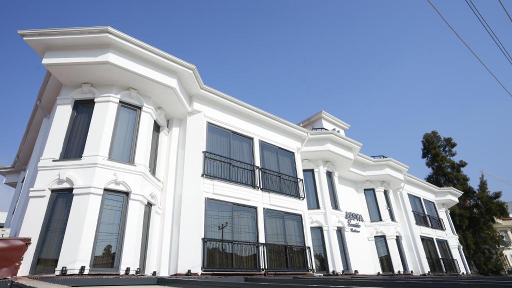 - un bâtiment blanc avec des fenêtres noires dans une rue dans l'établissement Alesta Seaside Residence, à Fethiye