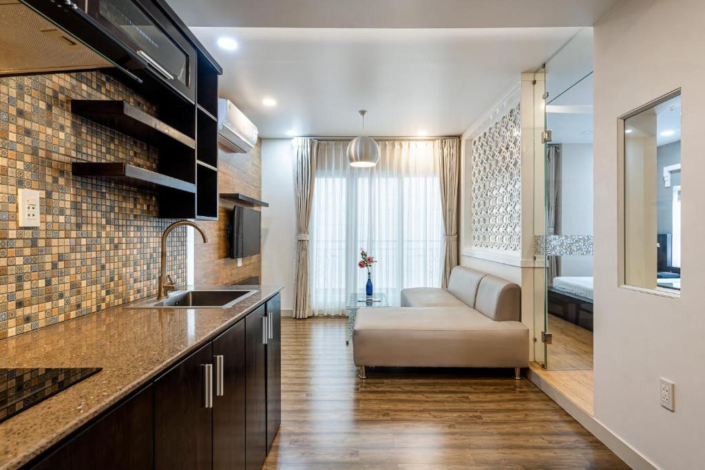 a kitchen with a sink and a couch in a room at SaiGon Huch Villa in Ho Chi Minh City
