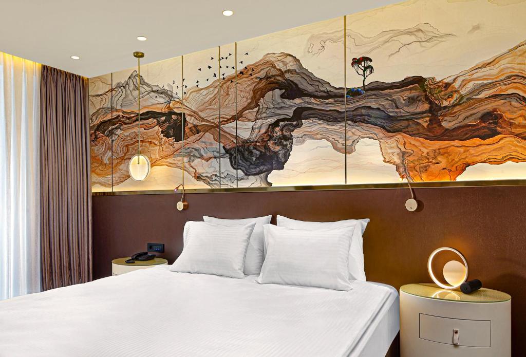 a bedroom with a bed and a large painting on the wall at The G Hotels Istanbul in Istanbul