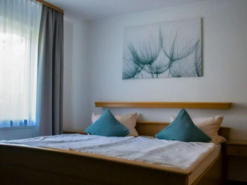 una camera con un letto con due cuscini blu di Haus am Park a Bad Soden-Salmünster