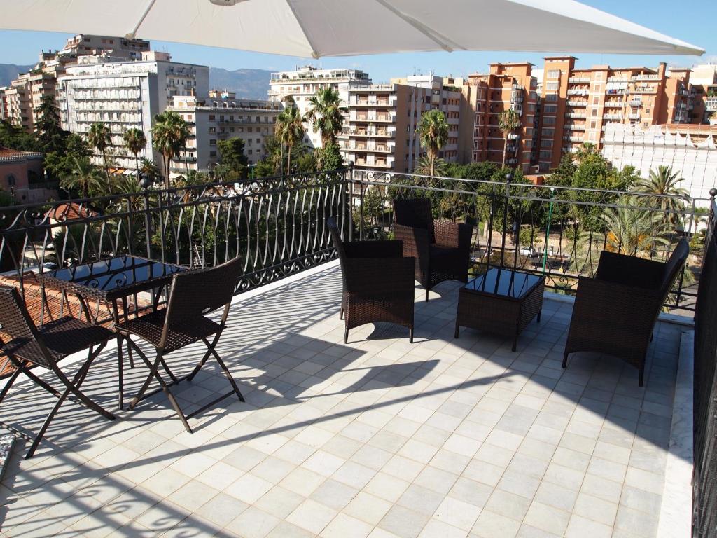 a patio with chairs and tables and an umbrella at Alberico Gentili in Palermo