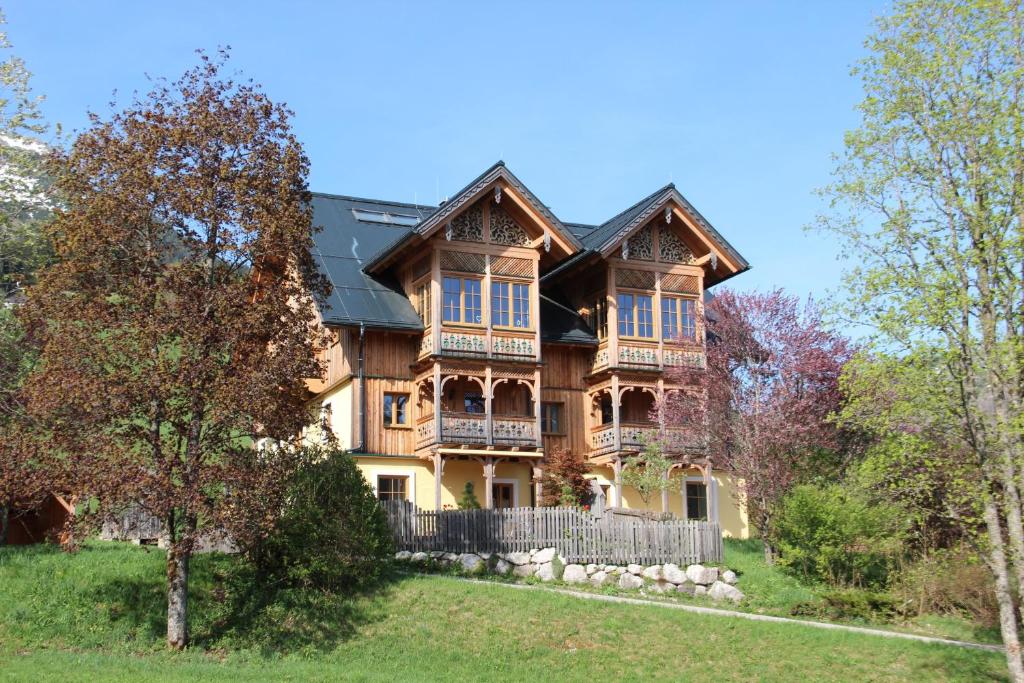 a large wooden house with a fence at Penthouse Weiglhof in Russbach am Pass Gschütt