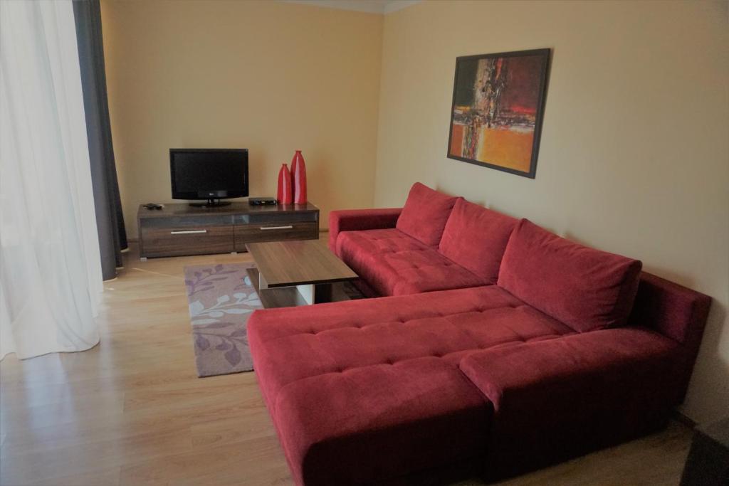 a living room with a red couch and a table at Penzión Villa in Rajecké Teplice