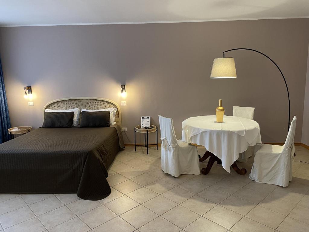 a bedroom with a bed and a table at Hotel Petrarca in Boara Pisani
