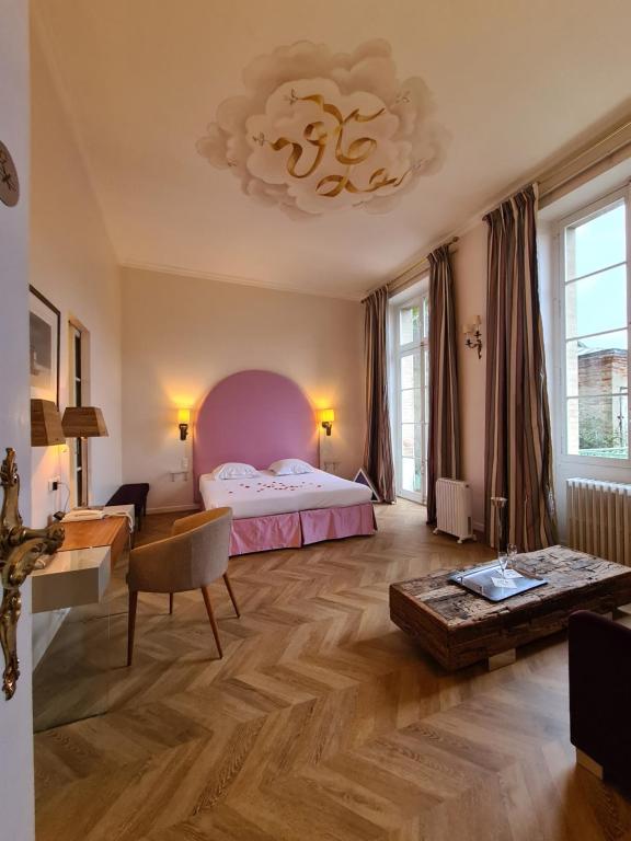 a bedroom with a bed and a desk and a chandelier at Villa Léopoldine in Grenade-sur-Garonne