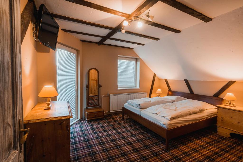 ein Schlafzimmer mit einem Bett, einer Kommode und zwei Lampen in der Unterkunft Cactus Snežienka in Regetovka