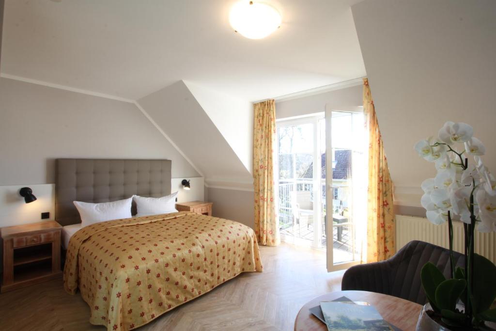 een slaapkamer met een bed en een groot raam bij Hotel Müritz-Park in Boek