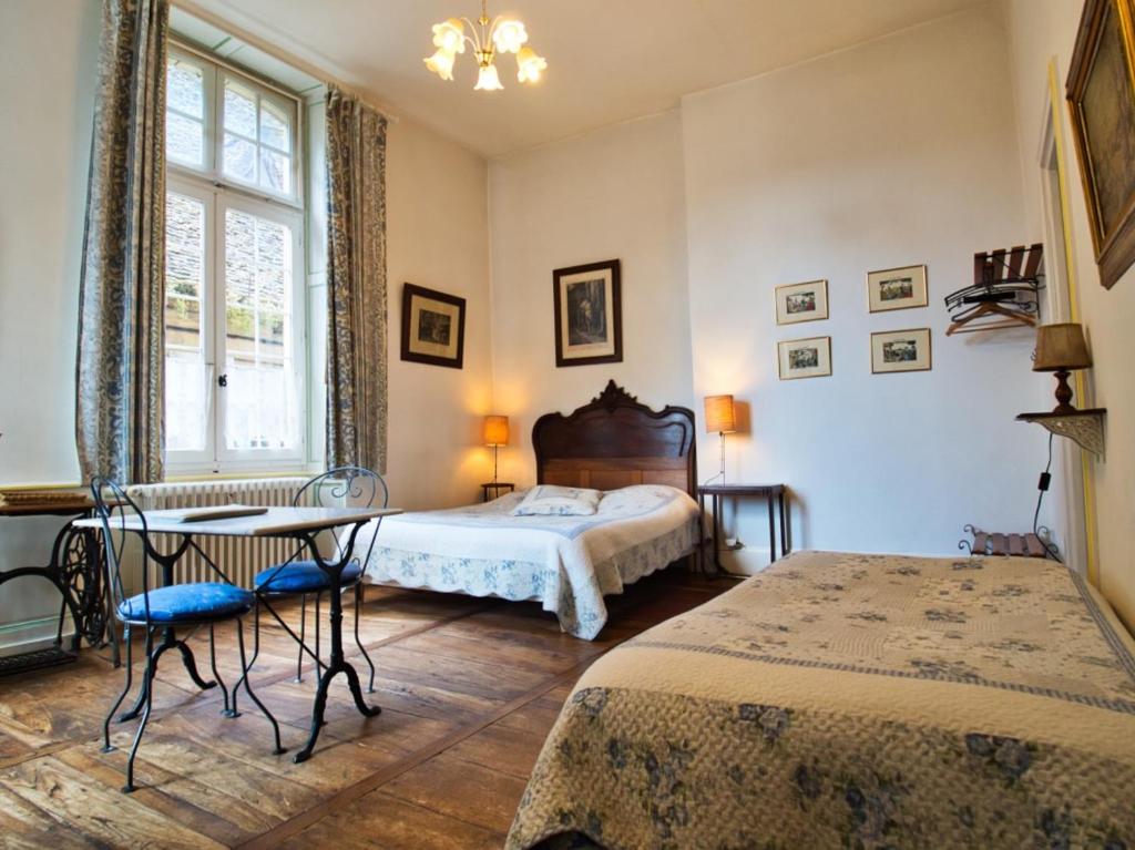 サルラ・ラ・カネダにあるLa Maison du Notaire Royalのベッドルーム1室(ベッド1台、テーブル、椅子付)