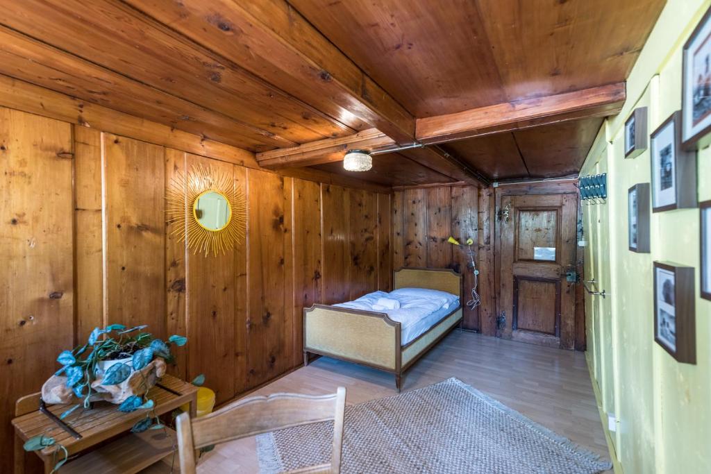 een kleine kamer met een bed in een houten muur bij Goya Onda in Morlon