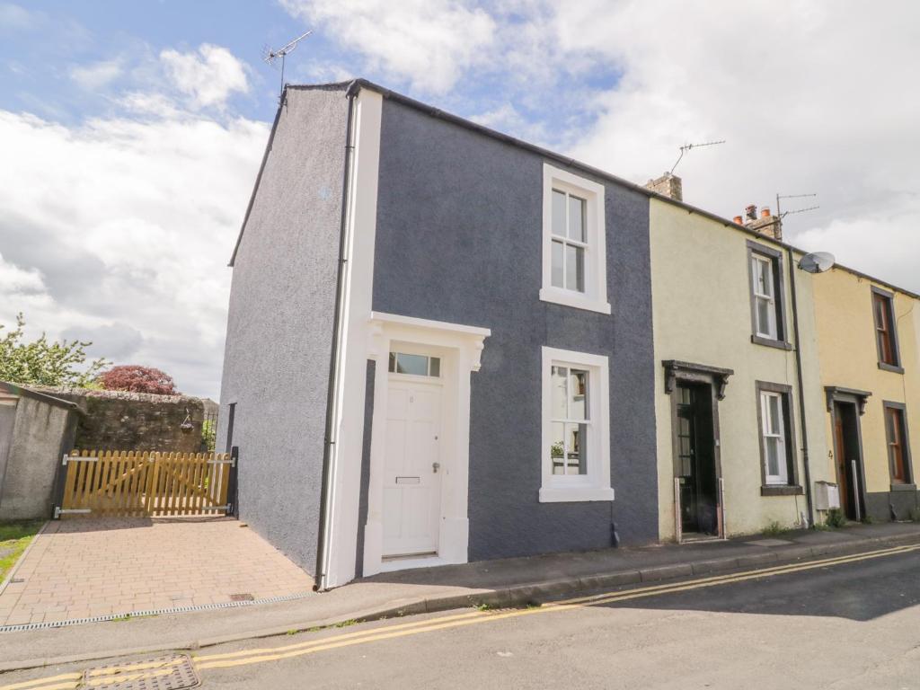 a house with a white door on a street at 8 Bridge Street in Cockermouth