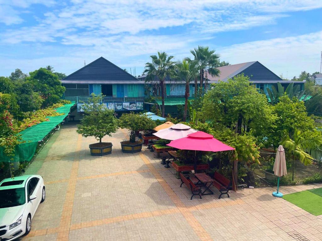 Tây Ninh的住宿－Khách sạn Vườn Cau & Khu vui chơi giải trí SaLa，享有带桌子和遮阳伞的庭院的空中景致