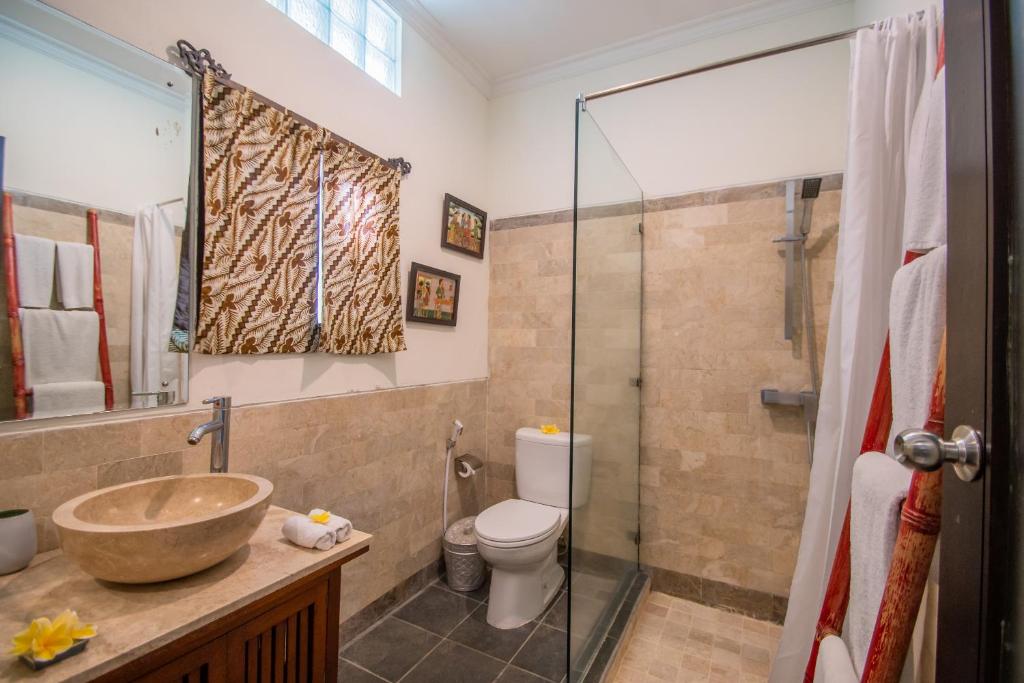 a bathroom with a sink and a toilet and a shower at Kembali Lagi Guest House in Sanur