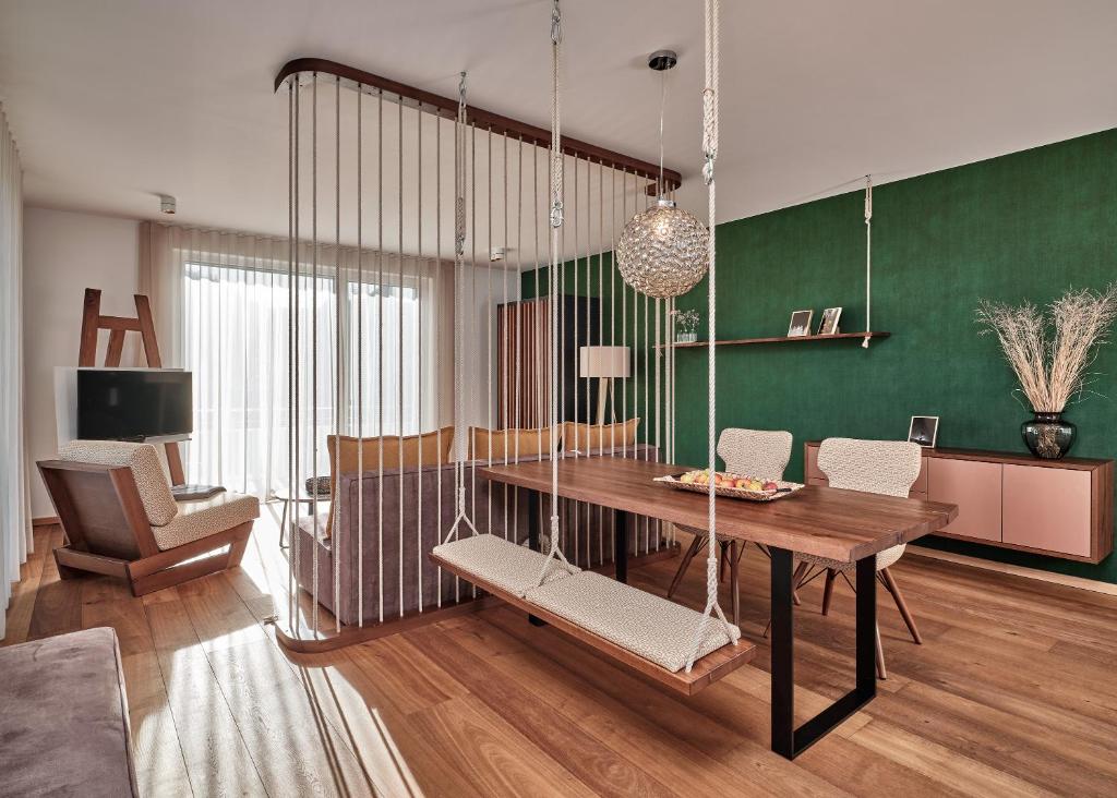 a living room with a table and a swing at WaldFunkeln LODGE in Hinterzarten