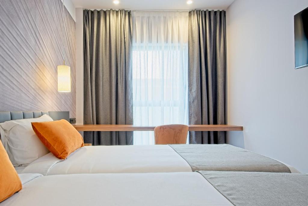 A bed or beds in a room at DWO Yuste Alcalá