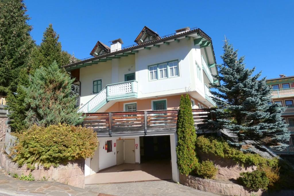 a white house with a balcony on top of it at Casa Al Mesdì in Pozza di Fassa