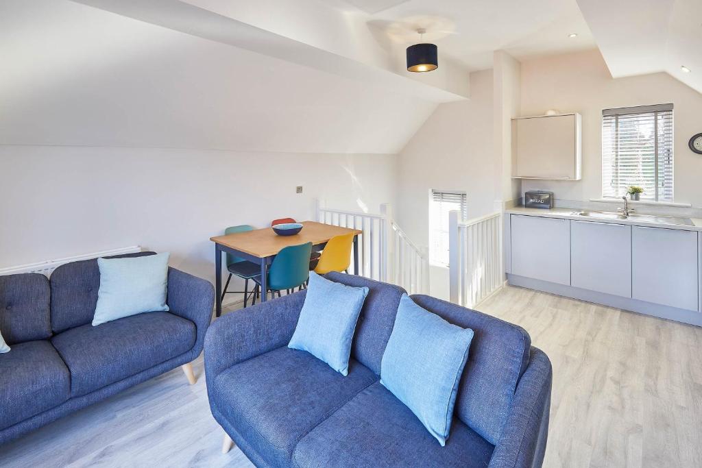 uma sala de estar com dois sofás azuis e uma cozinha em Host & Stay - Jet Cottage @ Spa Well em Whitby