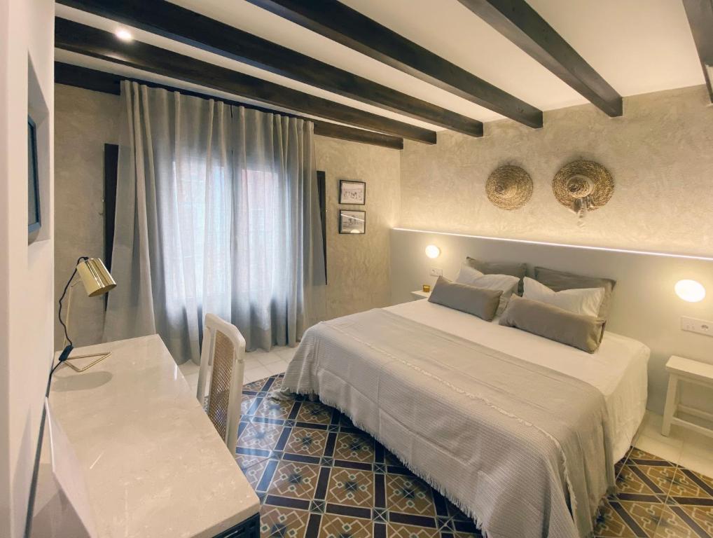 1 dormitorio con cama, mesa y escritorio en Terra i Mar, en Cabanes