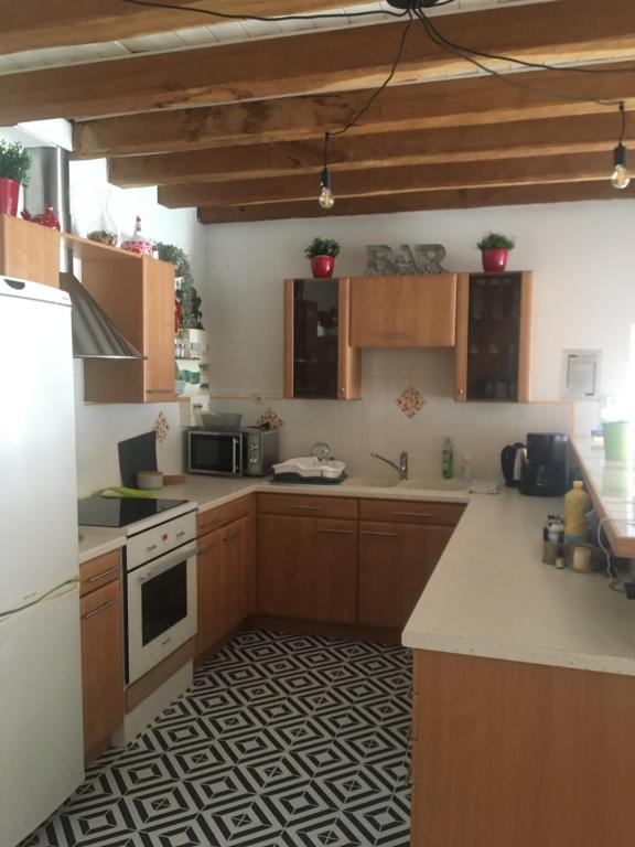 Una cocina con gabinetes de madera y un horno de estufa. en Proche Chambord La petite maison, en Thoury