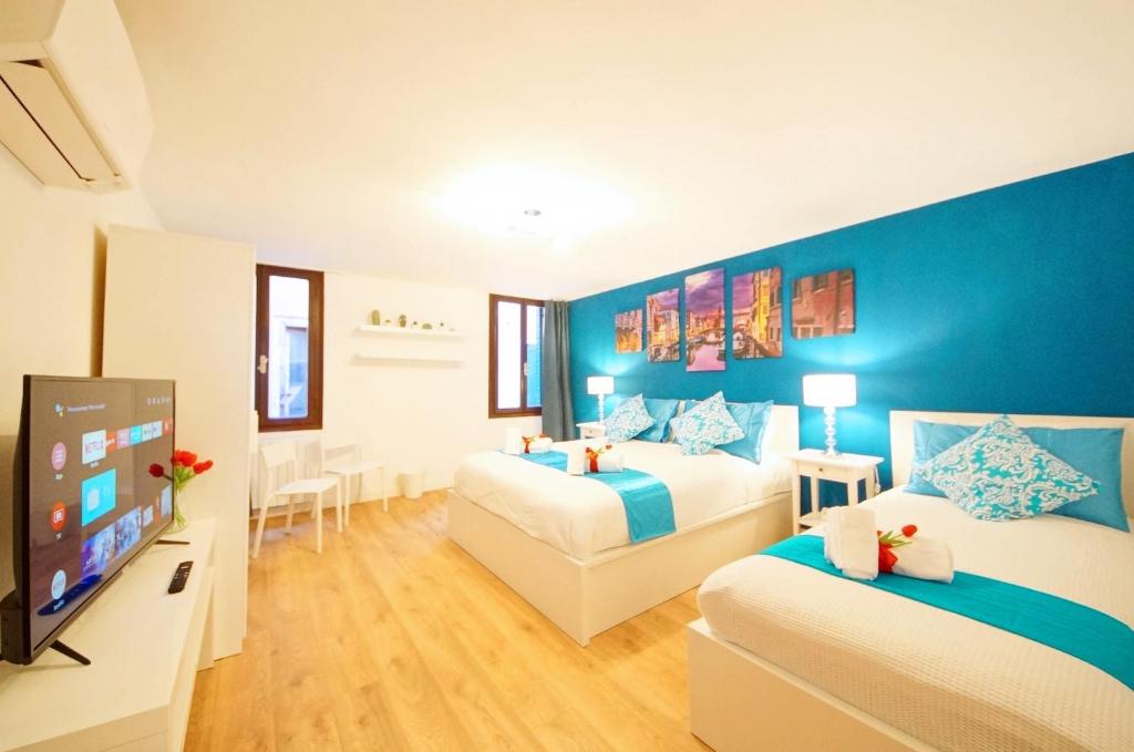 um quarto de hotel com duas camas e uma televisão de ecrã plano em Calle dei Fabbri Apartment Marble em Veneza