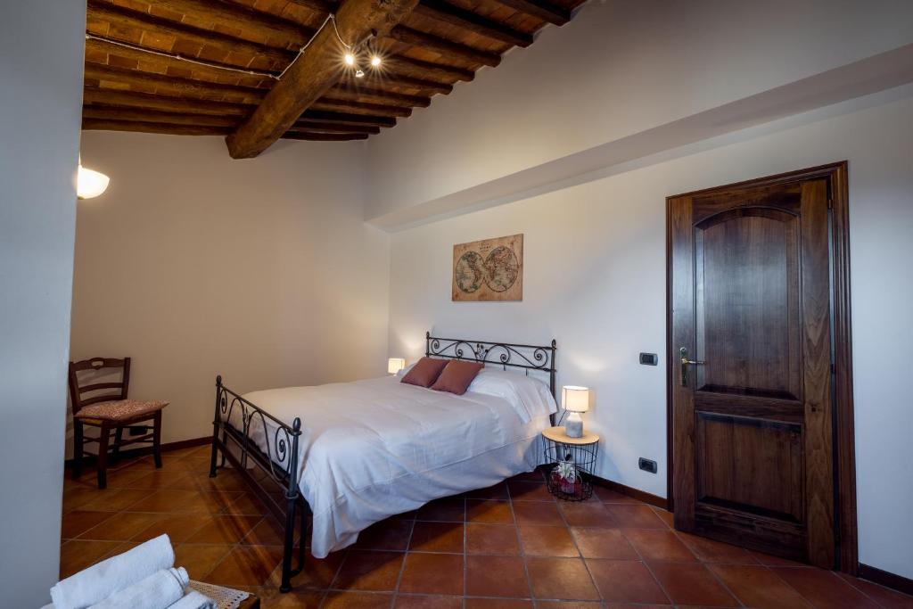 1 dormitorio con 1 cama y puerta de madera en Tognazzi Casa Vacanze - Casa Vico, en Zambra