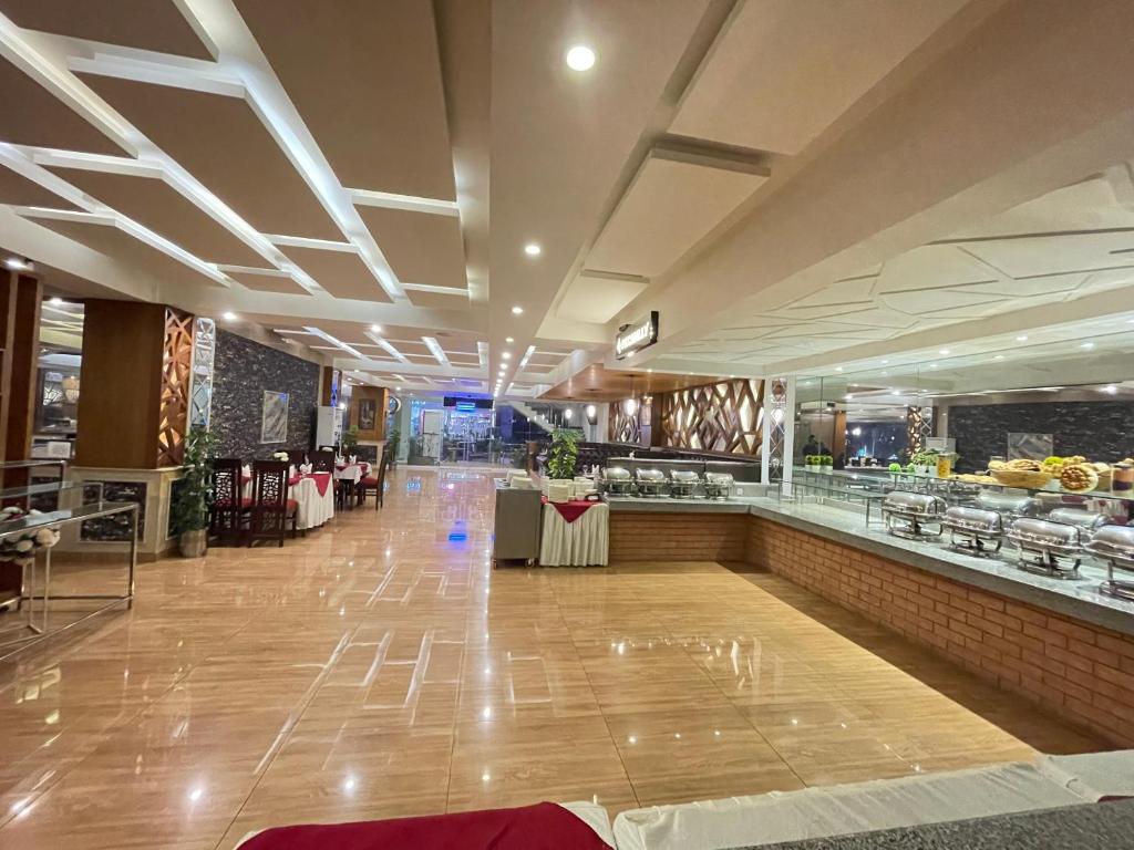 a restaurant with a long counter and a buffet at Grand Mongolia Hotel in Rawalpindi
