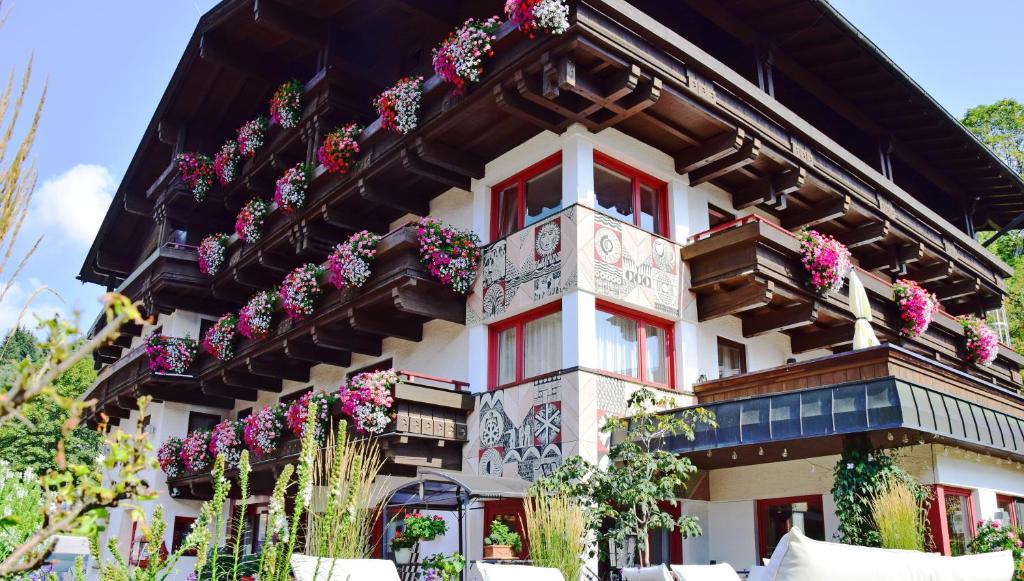 um edifício com flores ao lado em Hotel & Art Kristiana em Saalbach-Hinterglemm