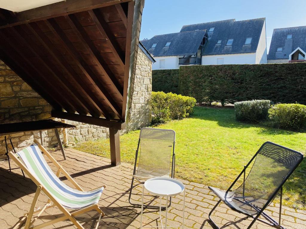 3 chaises et une table sur une terrasse dans l'établissement PORT AN DRO 2 - Jardin, Wifi, Plage 450m - DT17, à Carnac