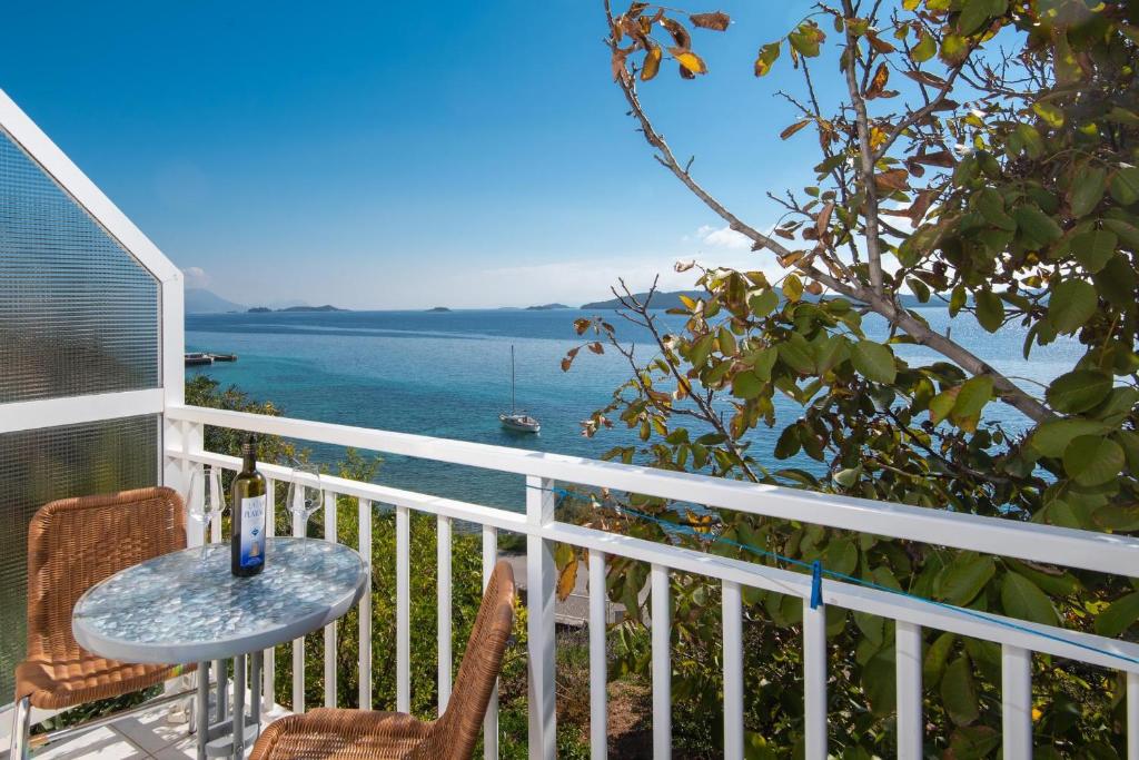 Un balcón con mesa y sillas y el mar. en Bella Perna Beachfront Apartments, en Kućište