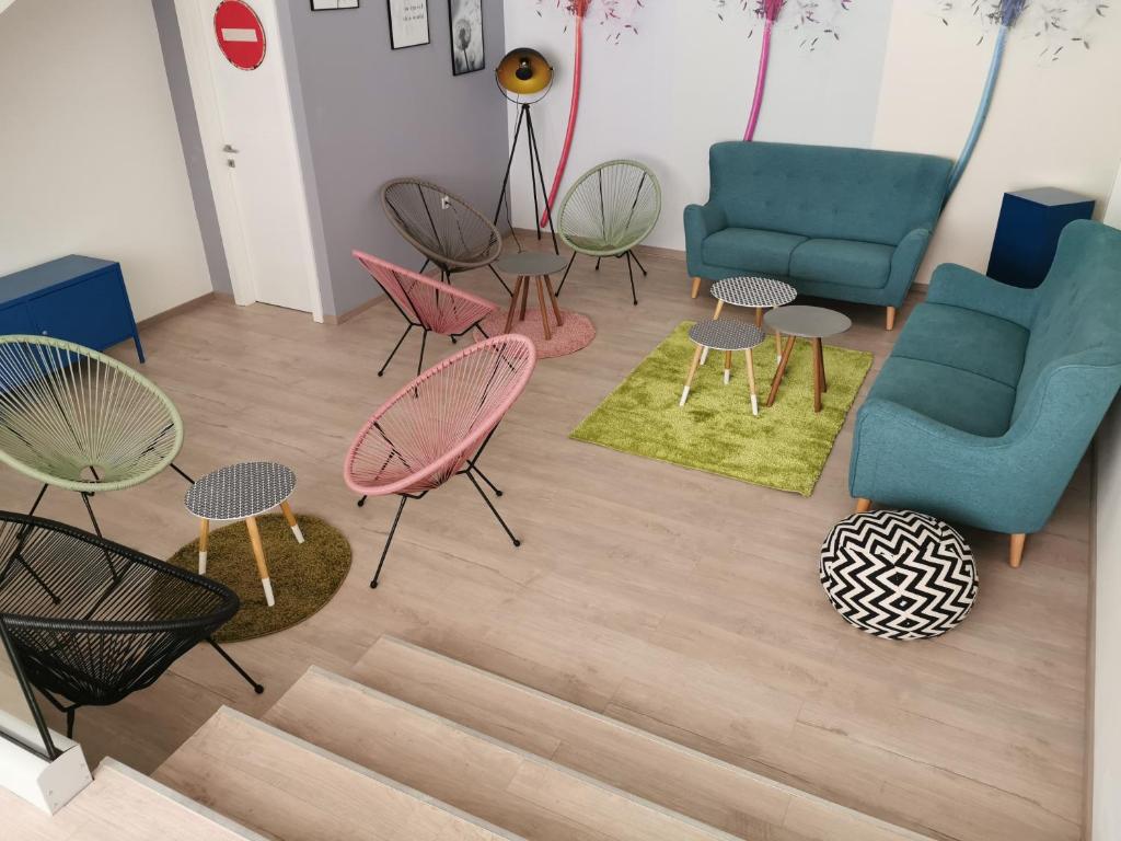 a living room with chairs and tables and a couch at Dandelion hostel in Zadar