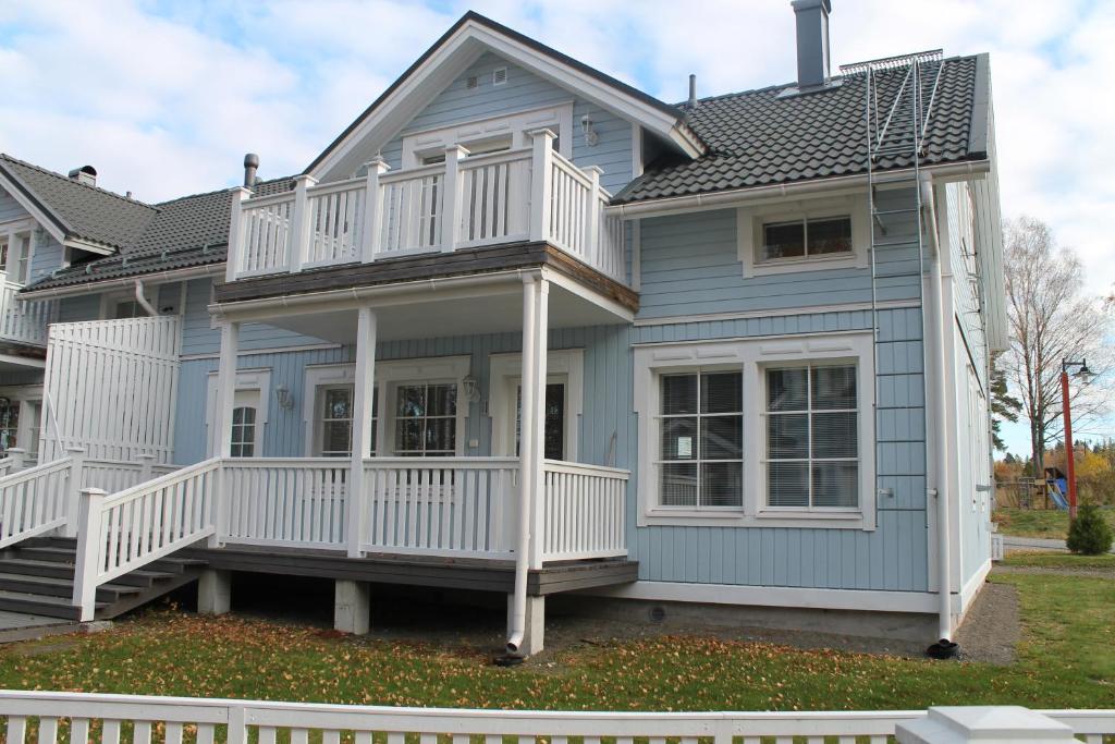 a large blue house with a white deck at SResort Apartment with 4 bedrooms in Imatra
