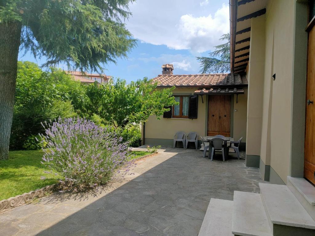 un patio de una casa con mesa y sillas en La Rosa appartamenti, en Monterchi