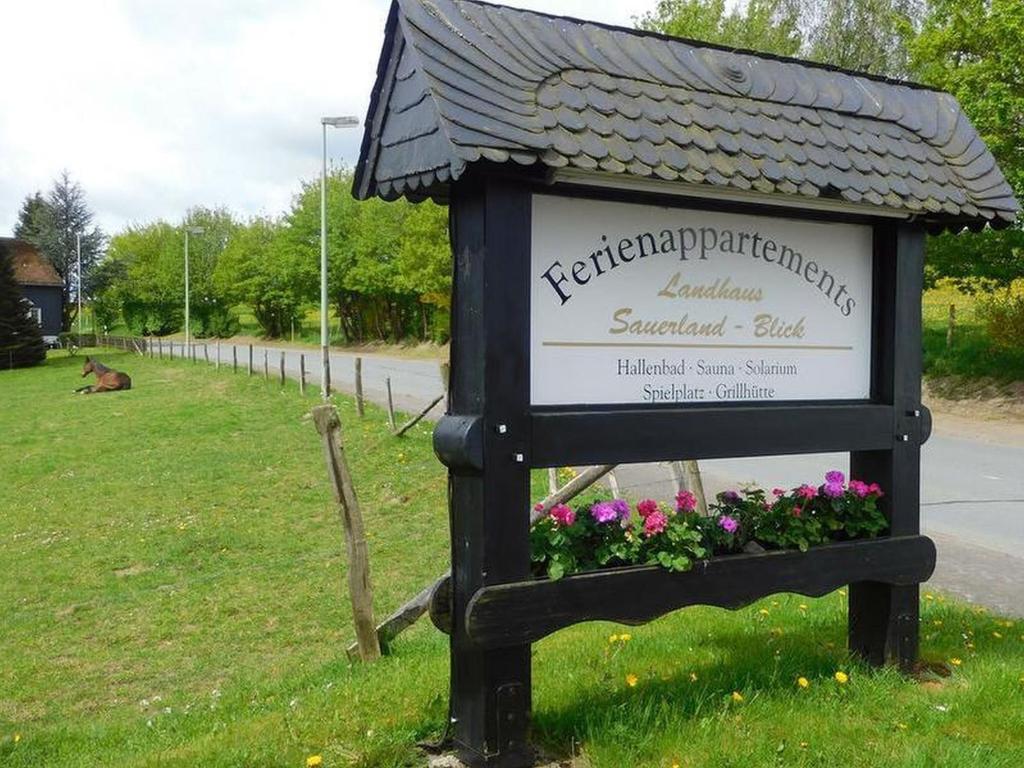 een teken in het gras naast een veld met bloemen bij Landhaus Sauerlandblick in Bestwig