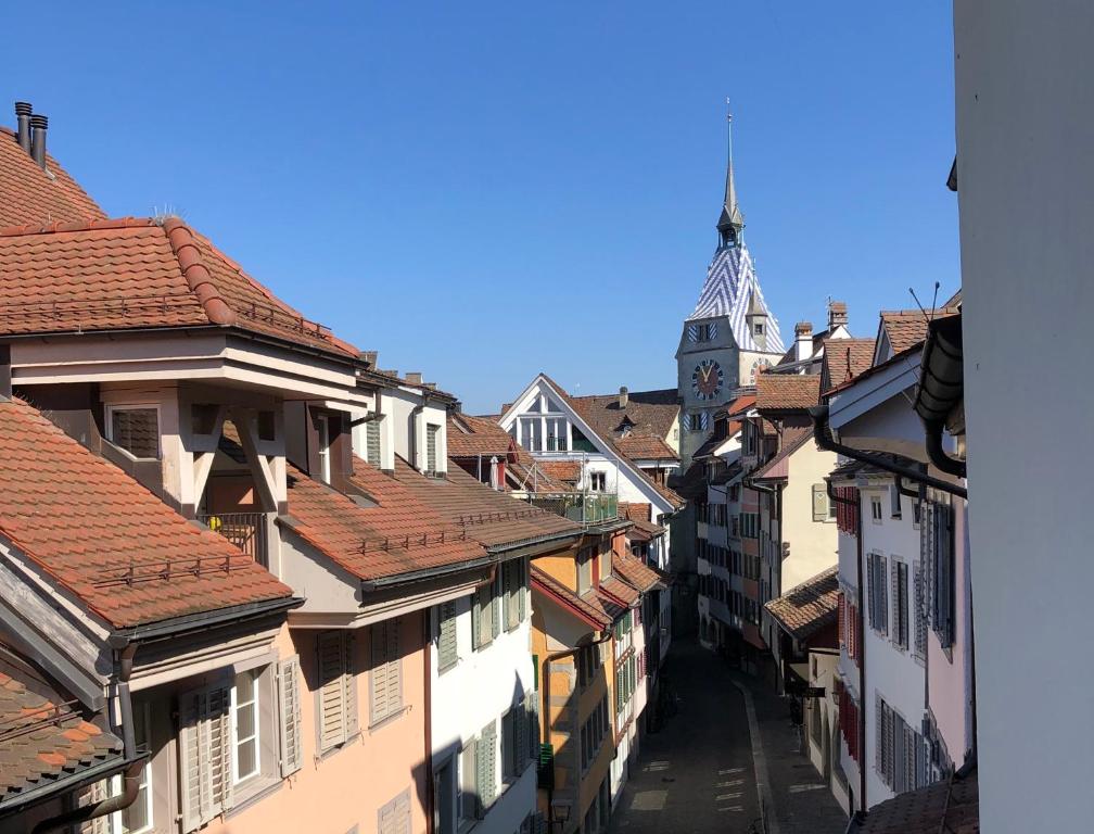 - une vue sur une rue de la ville avec une tour de l'horloge dans l'établissement Casa Koraal - Old Town Zug, à Zoug