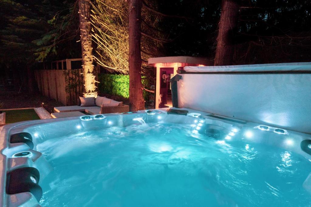 a hot tub in a backyard at night at Pink Spa Nest in Blairgowrie