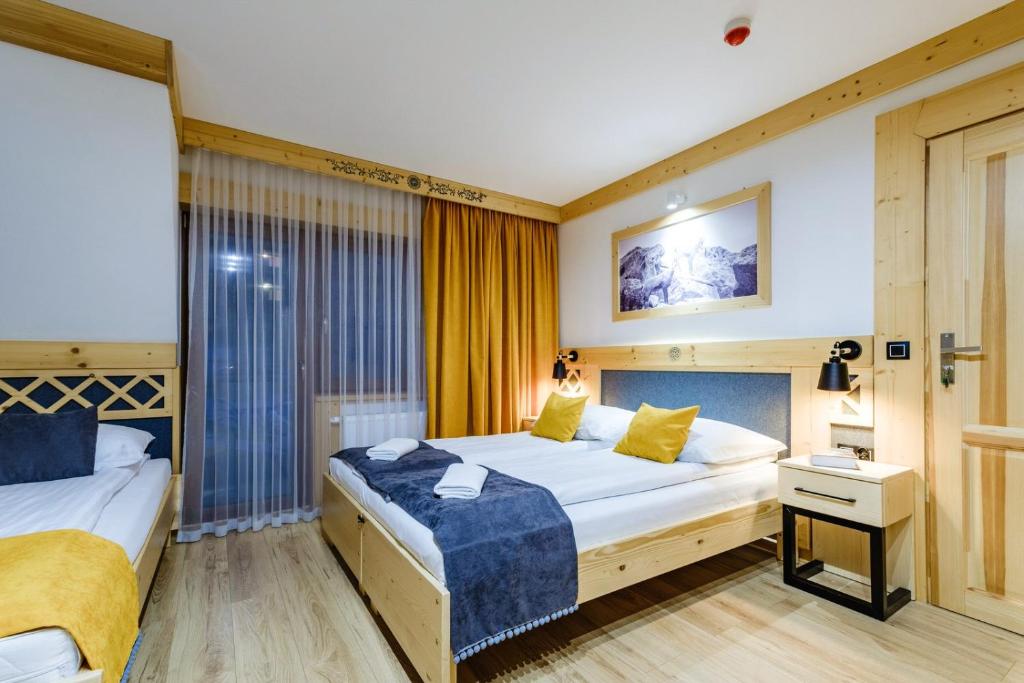 um quarto de hotel com duas camas e uma janela em Willa U GAŁÓW em Poronin