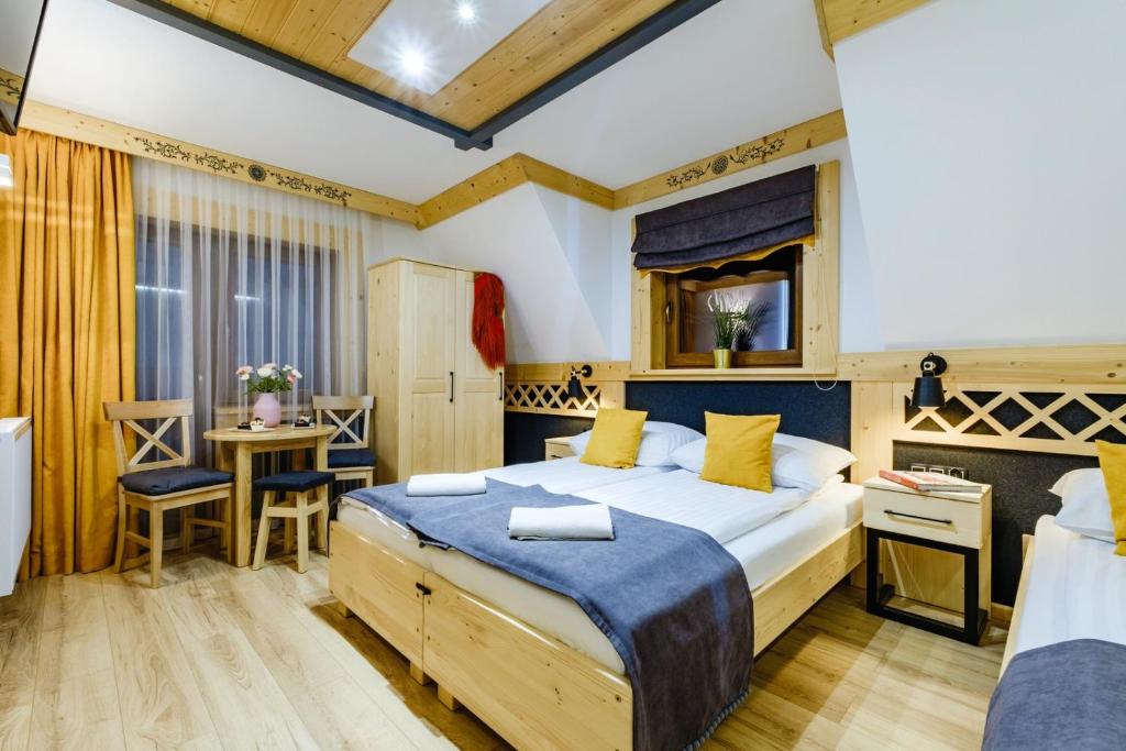 a bedroom with a large bed and a table and chairs at Willa U GAŁÓW in Poronin