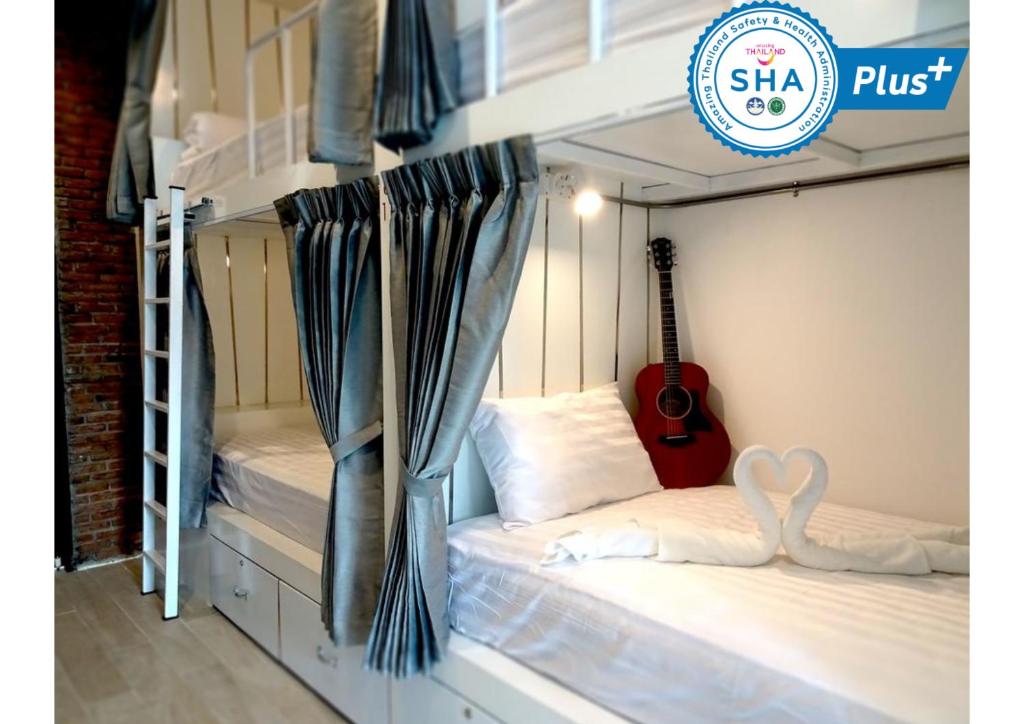 a bedroom with two bunk beds with a guitar at What's Up Chiang Mai in Chiang Mai