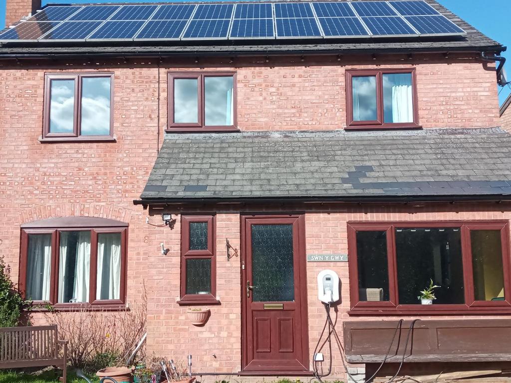 una casa de ladrillo con paneles solares en el techo en Swn Y Gwy ~ The Sound of the Wye, en Brecon