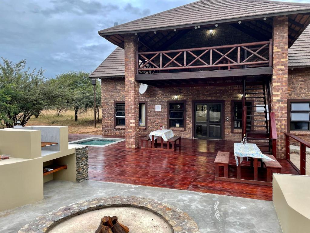 a house with a patio with a dog in front of it at Nghala Self-catering Holiday Home in Marloth Park
