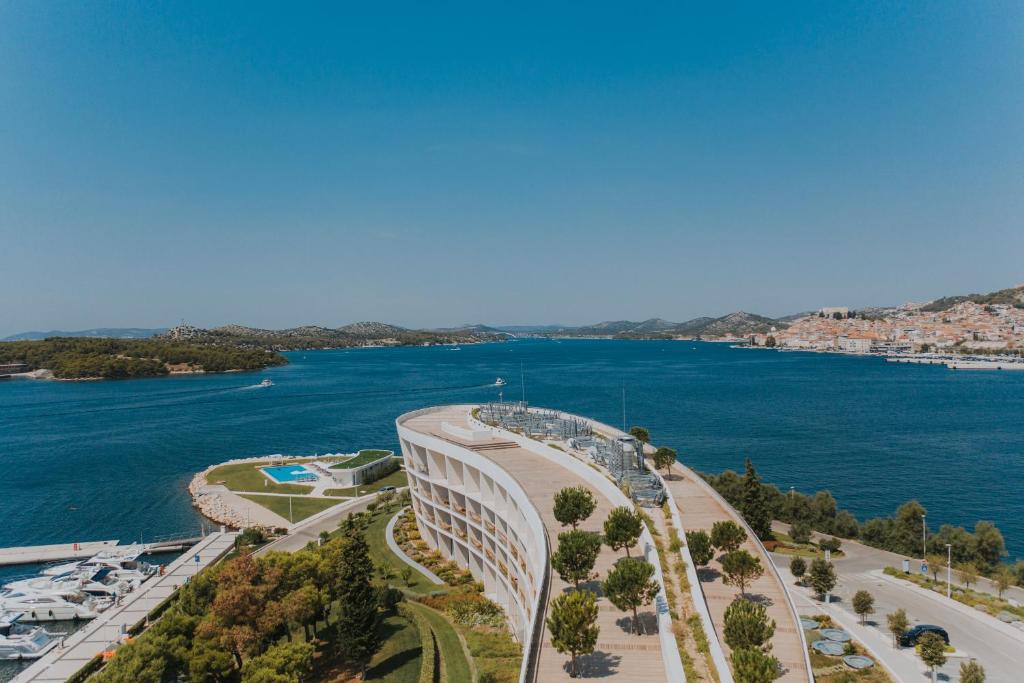 D-Resort Šibenik في شيبينيك: اطلالة جوية على مبنى بجانب تجمع المياه