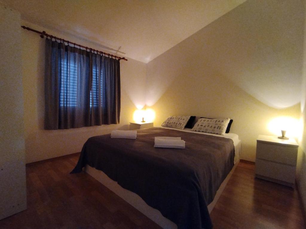 a bedroom with a bed with two lights on it at Ervin cosy two bedroom apartment center in Novalja