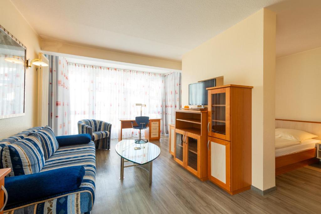 a living room with a couch and a tv at Appart-Hotel-Heldt in Bremen