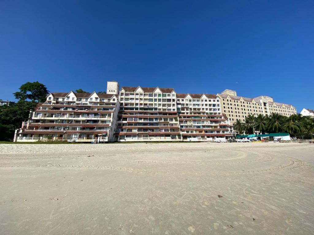 a large hotel on the beach with a sandy beach at Port Dickson Paradise Lagoon Beachfront Apartment in Port Dickson