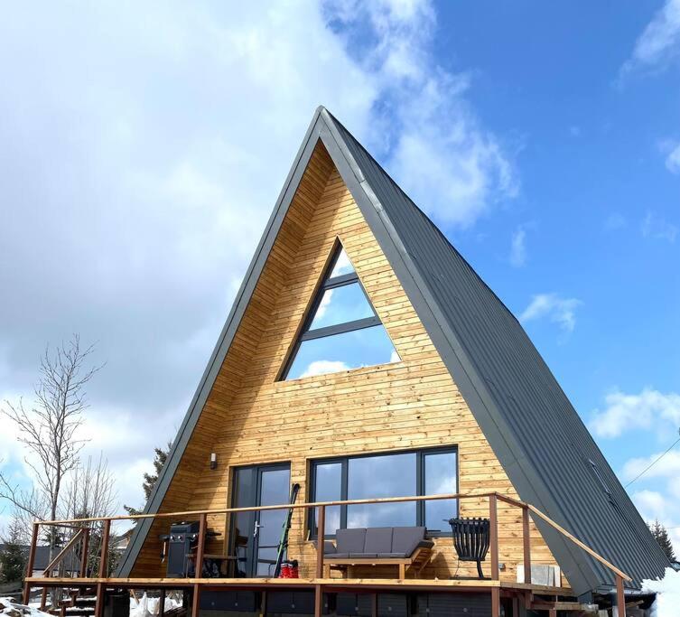 a house with a triangular roof with a balcony at A Marisel - 3 bedroom holiday home in Mărişel