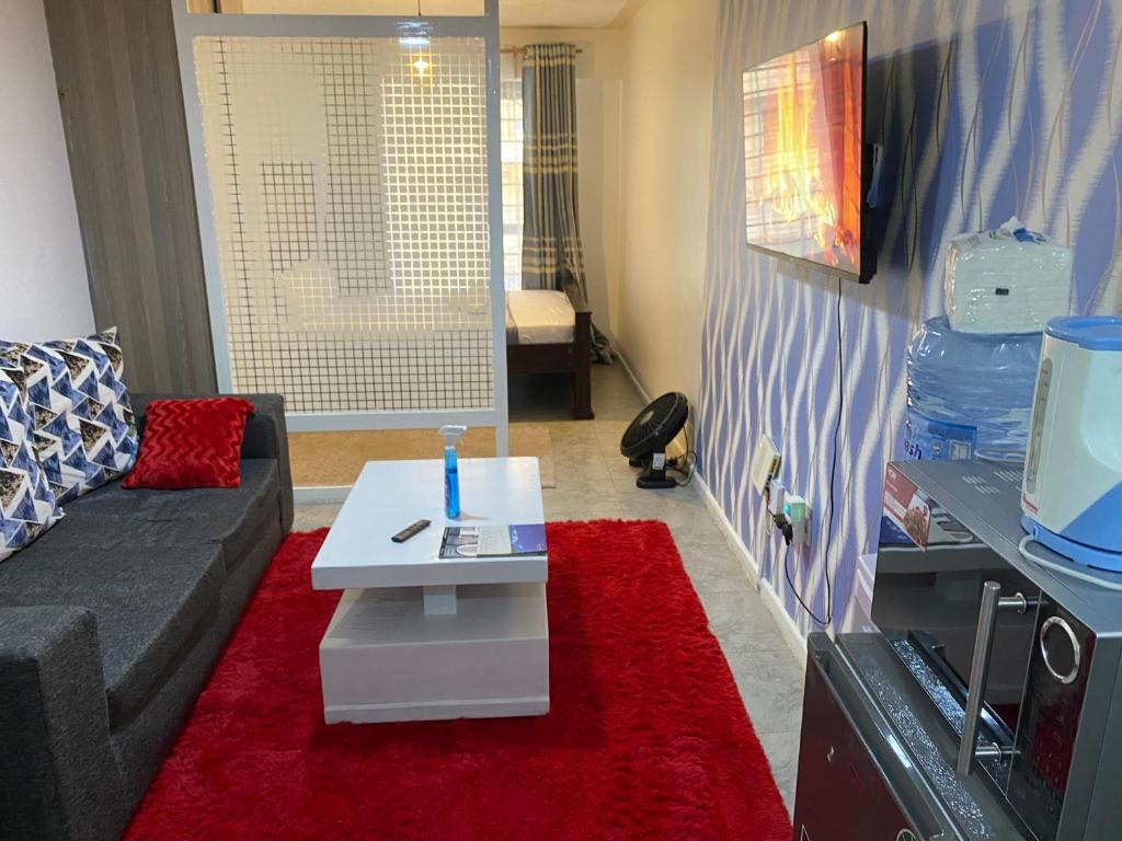 ein Wohnzimmer mit einer Couch und einem Couchtisch in der Unterkunft Andyhill Studio Apartment -Tsavo Embakasi Near Sgr in Nairobi