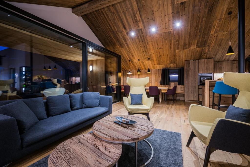 a living room with a blue couch and chairs at Chalet Ortles in San Valentino alla Muta